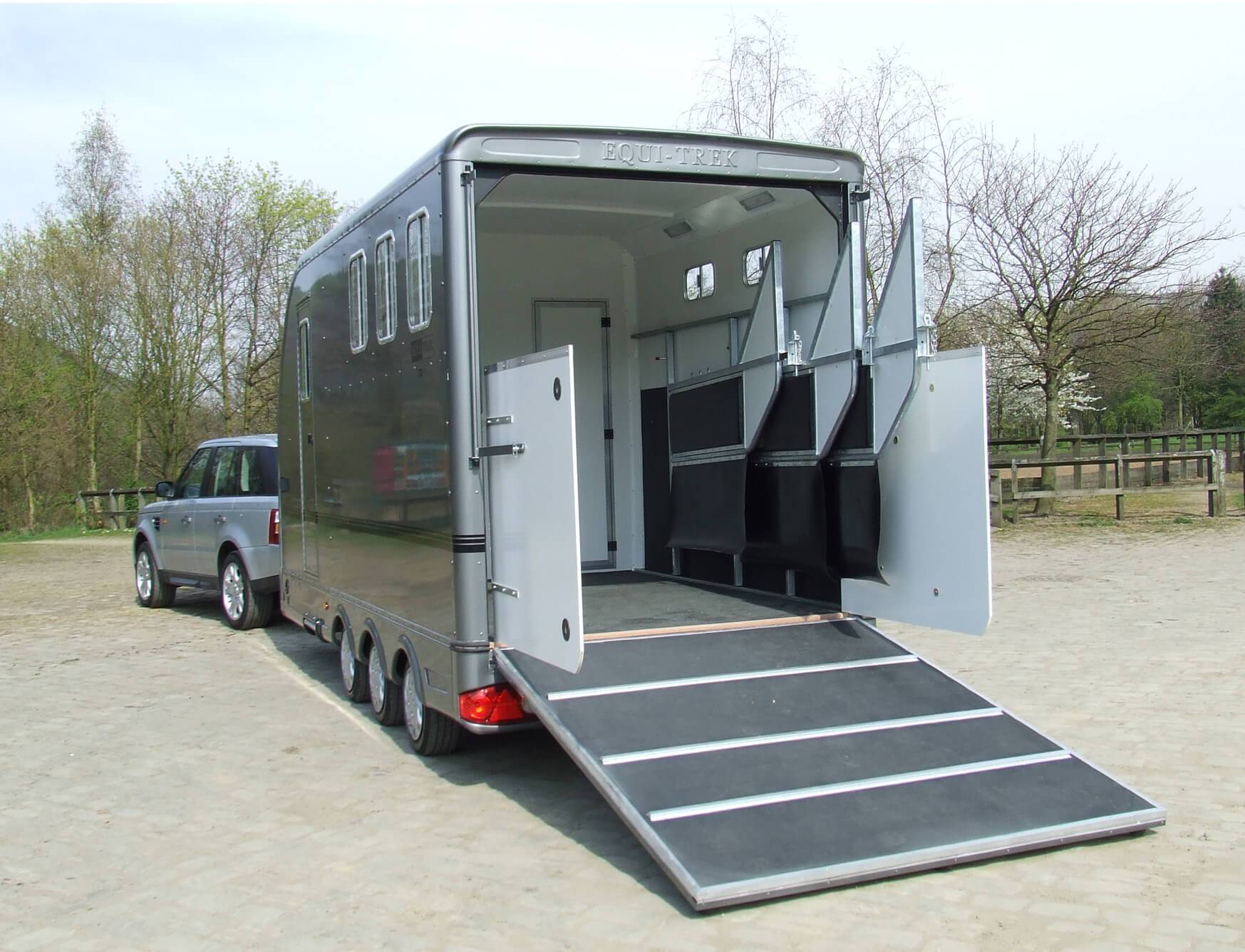 A horse trailer with its door open and ramp down ready for a horse to load up