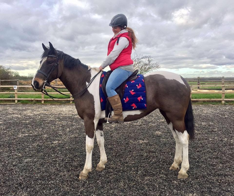 Pippa riding Lily in an equine arena