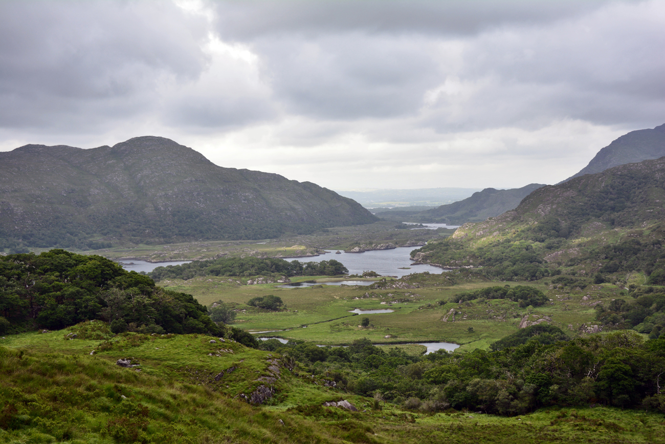 A vast view of low lying lakes and tall rocky hills in Ireland